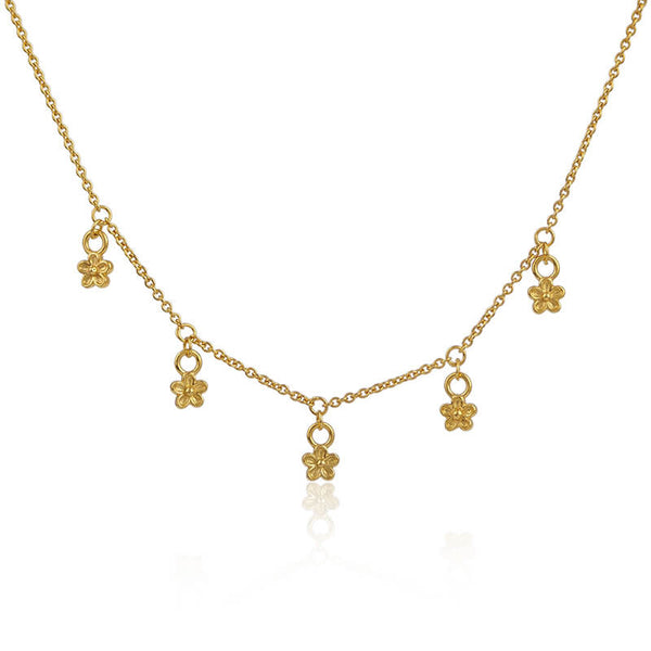 gold delicate necklace with five tiny flowers dangling from it