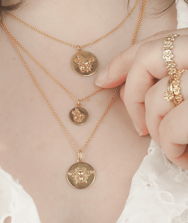 tiny flying bee coin necklace on model