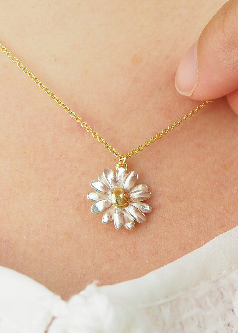 gold and silver daisy necklace on model