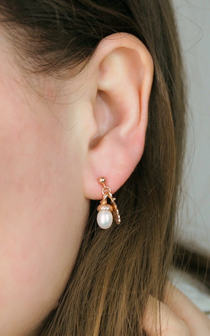 rose gold pearl acorn earrings on a model