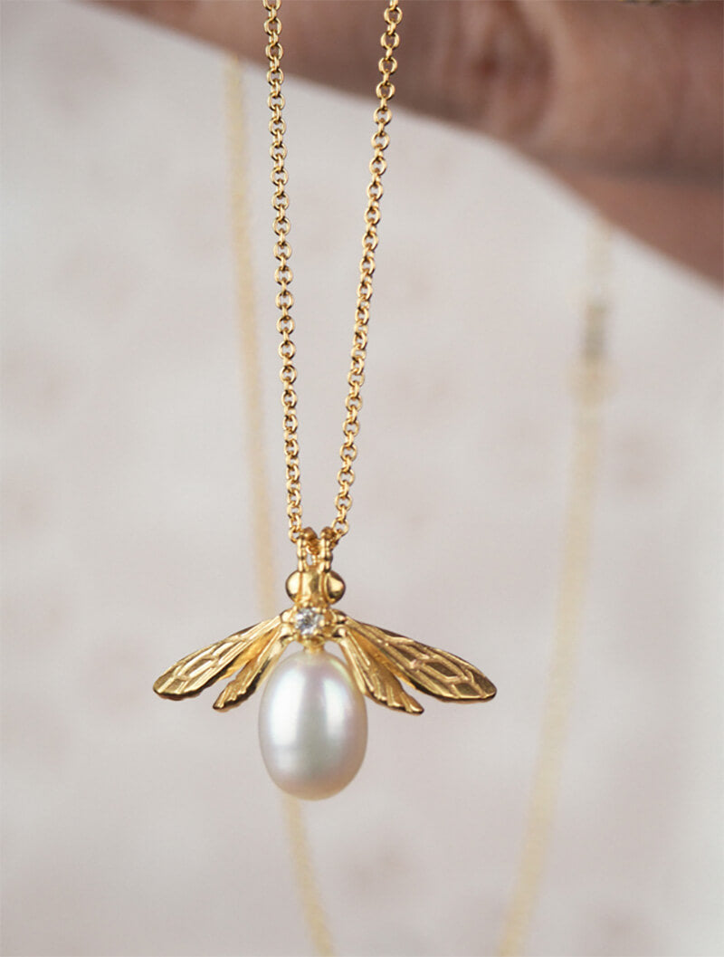 gold bee pendant with pearl body and small white sapphire